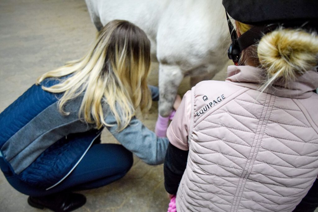 Barn, hest og forælder på staldgang