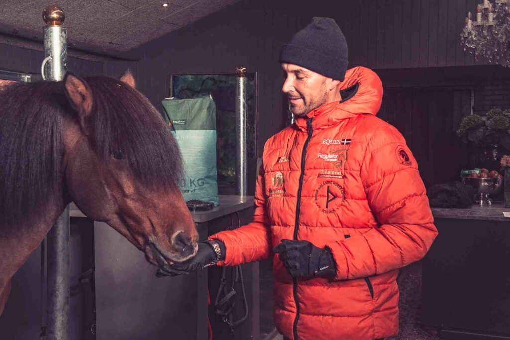 Nils Christian Larsen fodrer en hest