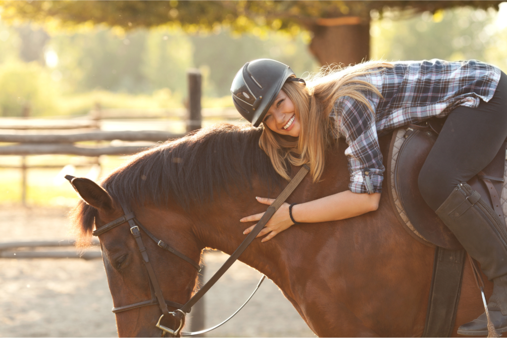 Pige smiler efter rideundervisning